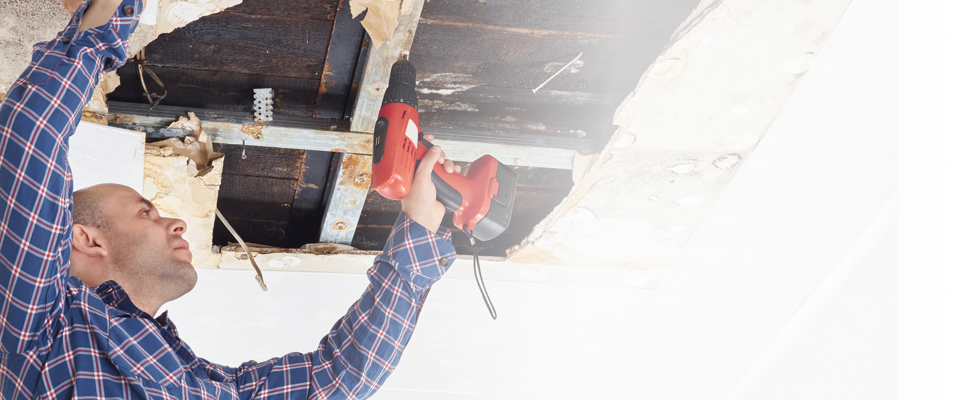 man fixing damaged ceiling